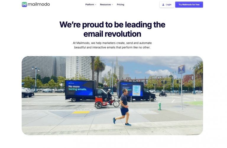 Homme courant devant véhicules publicitaires Mailmodo.